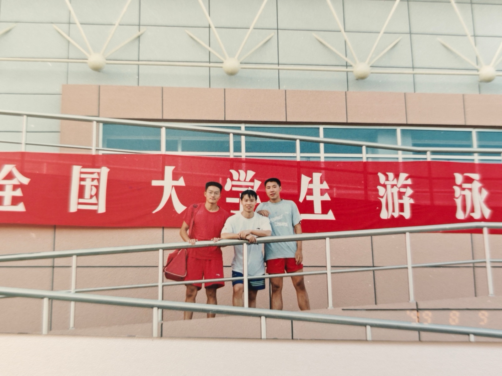 三位队员在比赛场馆合影